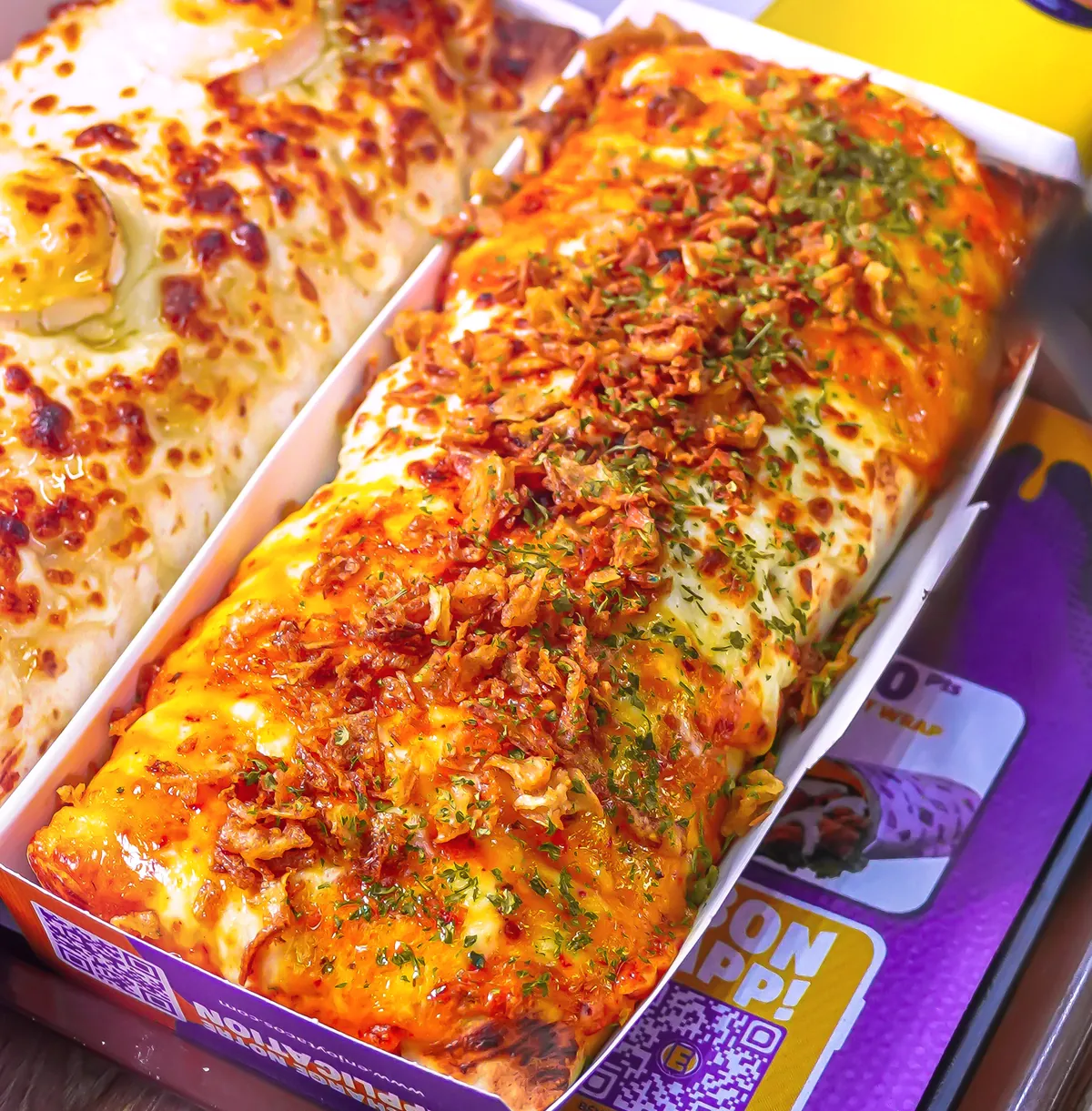 Gros plan sur un tacos nappé de fromage fondu gratiné et de persil